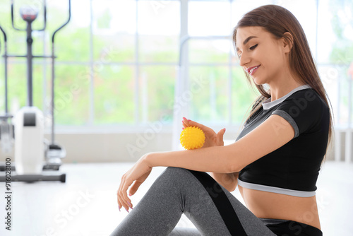 Sporty young woman massagin...