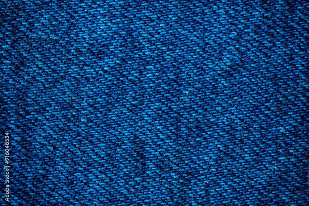 Texture of blue denim. Denim machine stitch. Can be used as background for lettering or design. Factory tailoring. Cotton fabric. Jeans fashion. Texture of blue denim. Denim machine stitch. Can be used as background for lettering or design. Factory tailoring. Cotton fabric. Jeans fashion.