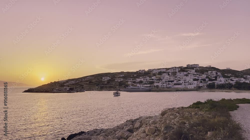 Golden hues fill the sky as the sun sets over Donousa, highlighting the serene village and gentle waves lapping at the shoreline. Golden hues fill the sky as the sun sets over Donousa, highlighting the serene village and gentle waves lapping at the shoreline.