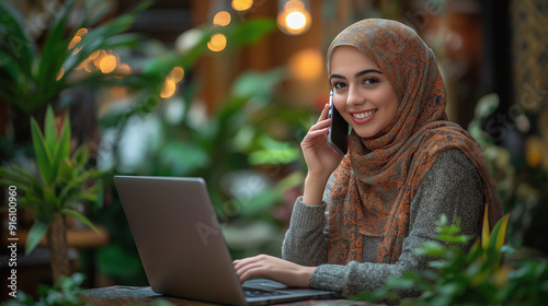 Smiling Muslim Woman in Hijab Working on Laptop and Talking on Phone for Modern Business and Technology Photography Themes photo