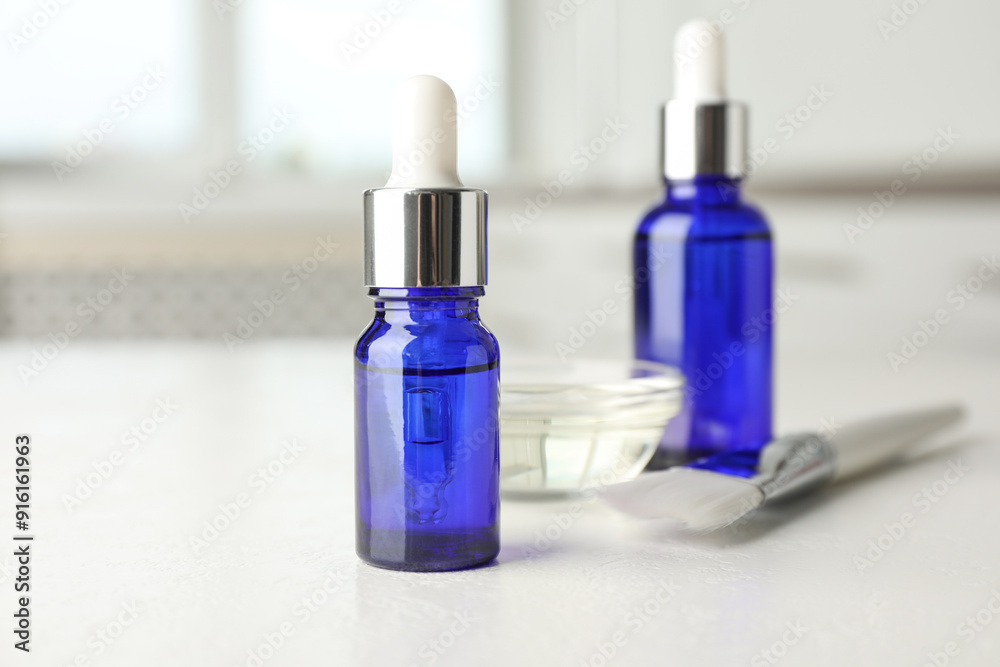 Peeling procedure. Bottles of chemical peel, bowl with liquid and brush on white table indoors Peeling procedure. Bottles of chemical peel, bowl with liquid and brush on white table indoors