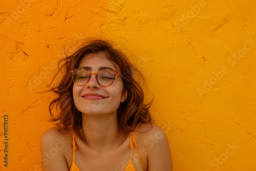 Uma bela mulher jovem, em um fundo de uma parede laranja. photo