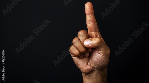 Single hand gesturing victory symbol against black background