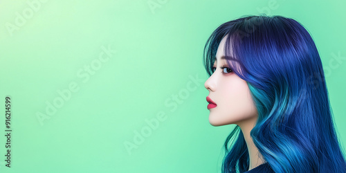 A profile view of a woman with vibrant blue hair against a gradient background.