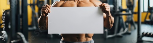 Bodybuilder holding blank sign in gym, perfect for fitness, promotion