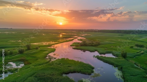 Sunset Over a Winding River in a Lush Green Meadow