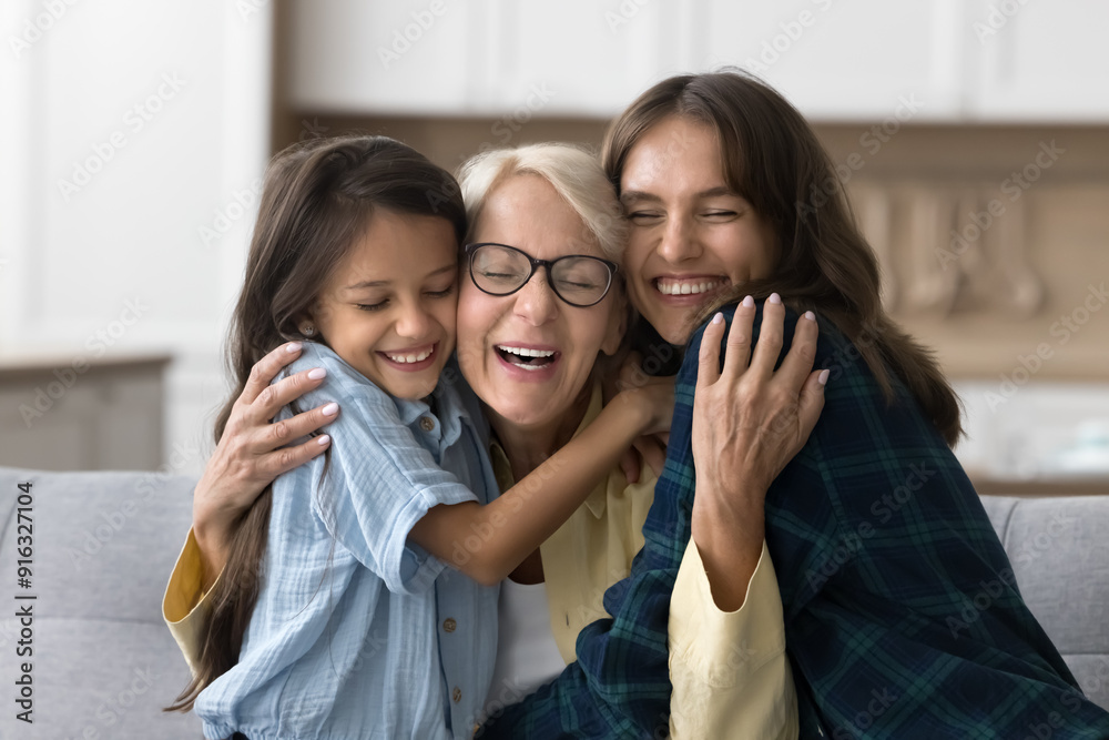Happy joyful granny hugging adult daughter and granddaughter kid with warmth, tenderness, love, smiling with closed eyes, enjoying family bonding, relations of generations Happy joyful granny hugging adult daughter and granddaughter kid with warmth, tenderness, love, smiling with closed eyes, enjoying family bonding, relations of generations