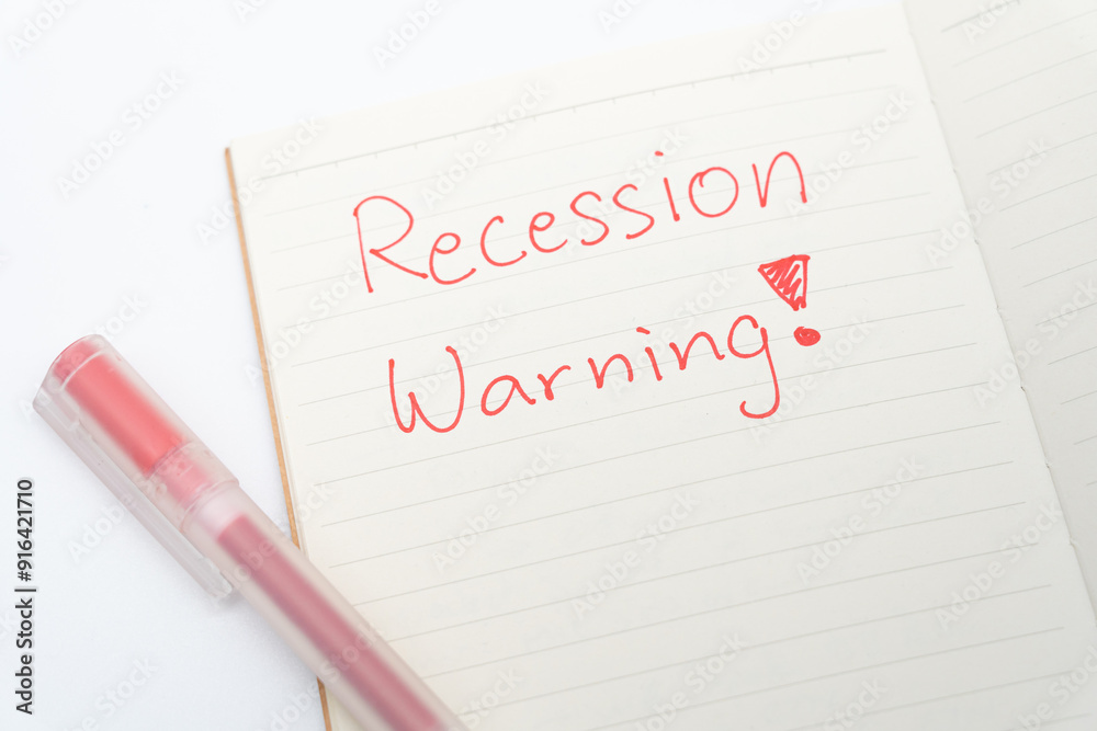 Hand writing Recession Warning on notebook. Global economic crisis. Recession business and stock crisis concept. Hand writing Recession Warning on notebook. Global economic crisis. Recession business and stock crisis concept.