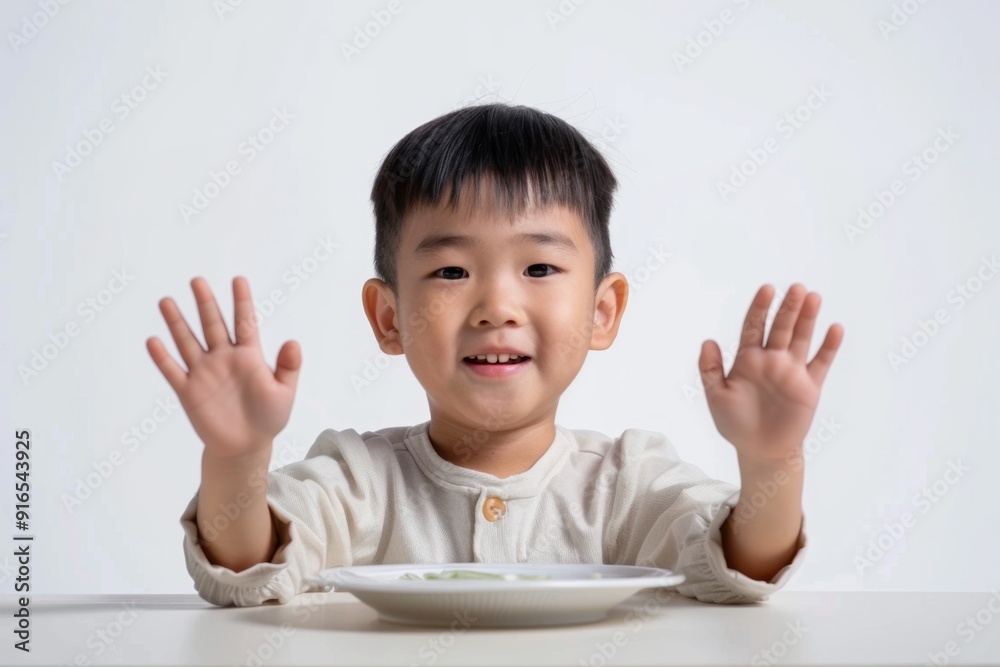 Innocent child playful expression eagerly smiles. Cheerful child shows enthusiasm mealtime hands raised. Innocent exuberance of young boy's mealtime. Innocent child playful expression eagerly smiles. Cheerful child shows enthusiasm mealtime hands raised. Innocent exuberance of young boy's mealtime.
