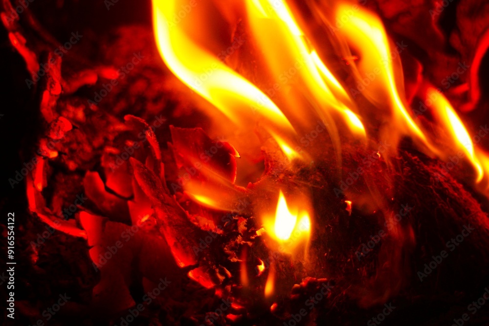 Close up of burning wood logs blazing in flames inside black wrought iron wood burning fire. Close up of burning wood logs blazing in flames inside black wrought iron wood burning fire.