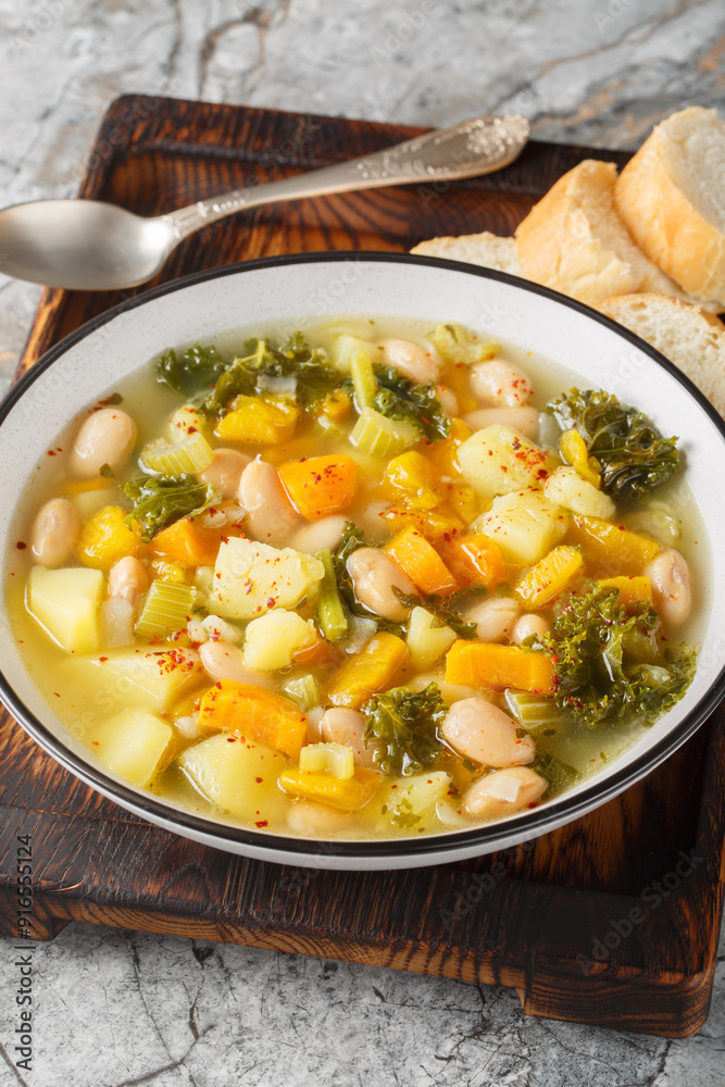 Zuppa Frantoiana italian bean soup with pumpkin and vegetables closeup on the bowl on the wooden board. Vertical Zuppa Frantoiana italian bean soup with pumpkin and vegetables closeup on the bowl on the wooden board. Vertical