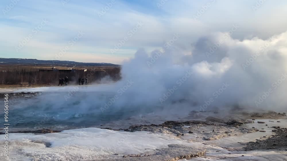 Geyser erupts in Iceland's geothermal landscape during a clear afternoon. A powerful geyser shoots steam into the sky against a backdrop of rugged terrain in Iceland on a sunny day. Geyser erupts in Iceland's geothermal landscape during a clear afternoon. A powerful geyser shoots steam into the sky against a backdrop of rugged terrain in Iceland on a sunny day.