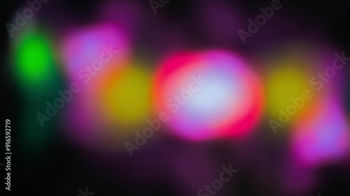 Multicolored abstract blurred background with changing and dynamic undefined shapes moving on a dark background. Blue, pink, purple, green color lights. Pulsating objects merging and dividing. 4K.