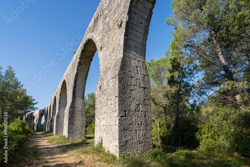 Landscape perspective view of ancient stone aqueduct, famous historic landmark of Castries, Herault, France