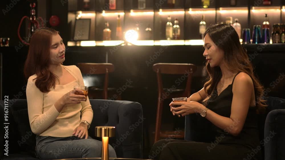 Cheerful female friends talking and enjoying drinks at luxury night club. Nightlife, celebrations and friendship concept