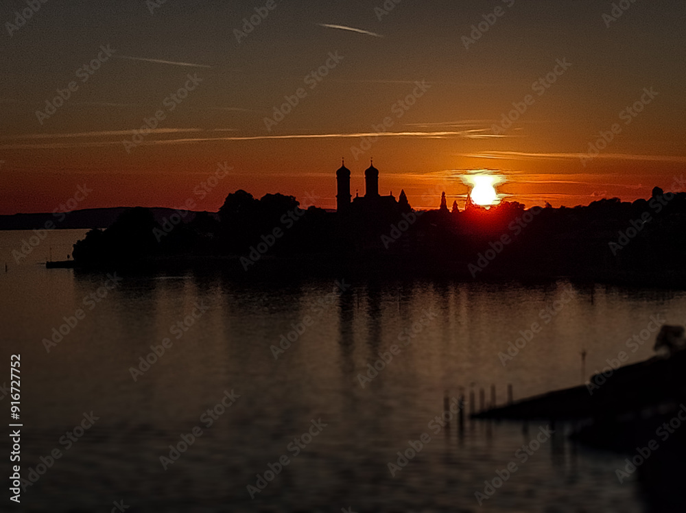 Ein dramatischer Sonnenuntergang über einer Stadt, wobei die Silhouetten von Gebäuden und Türmen im Vordergrund erscheinen und eine mystische Stimmung erzeugen Ein dramatischer Sonnenuntergang über einer Stadt, wobei die Silhouetten von Gebäuden und Türmen im Vordergrund erscheinen und eine mystische Stimmung erzeugen