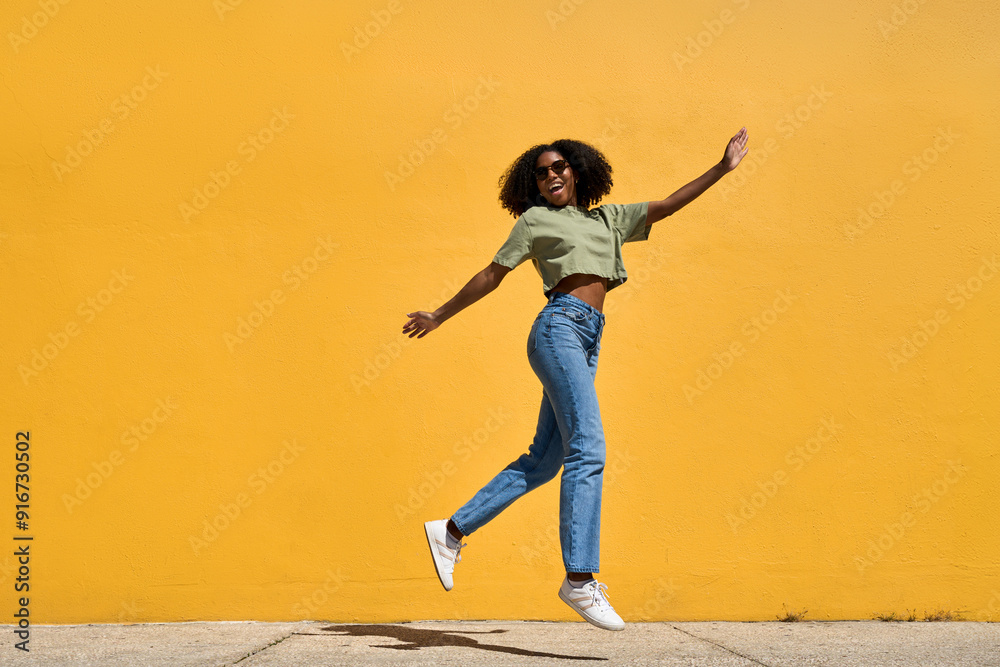Happy cheerful young African American woman winner jumping flying in ...