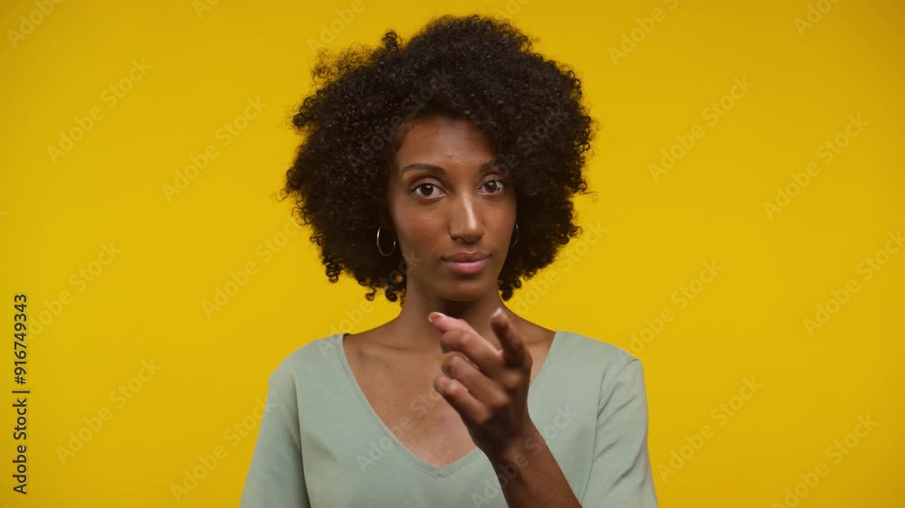 Woman with Curly Hair Gesturing No with Finger Against Yellow Background Woman with Curly Hair Gesturing No with Finger Against Yellow Background