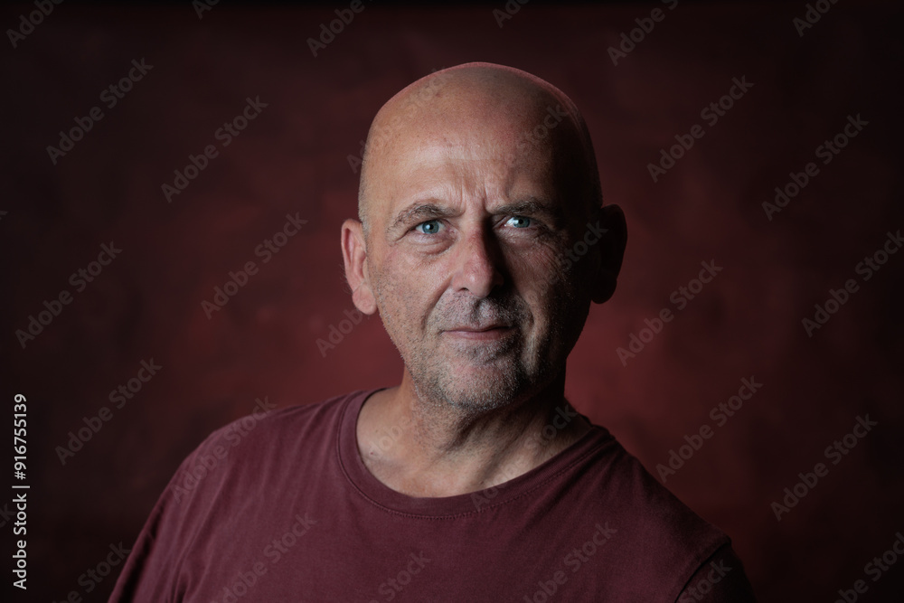 Mature man with shaved head and goatee posing on red background Mature man with shaved head and goatee posing on red background