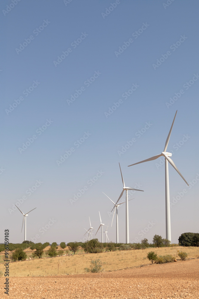 Wind turbines in a dry landscape under a clear sky Wind turbines in a dry landscape under a clear sky