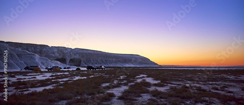 (Super wide view) Steep chalk cliffs and tent night in the glow of the Golden Hour in Mangistau, Kazakhstan