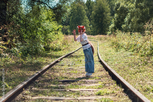 A girl with cat mask, tail and gloves doing Quadrobics in the forest.