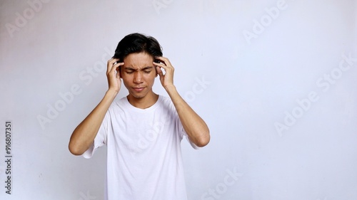 Asian young man wearing white shirt gesture hand holding head . headache