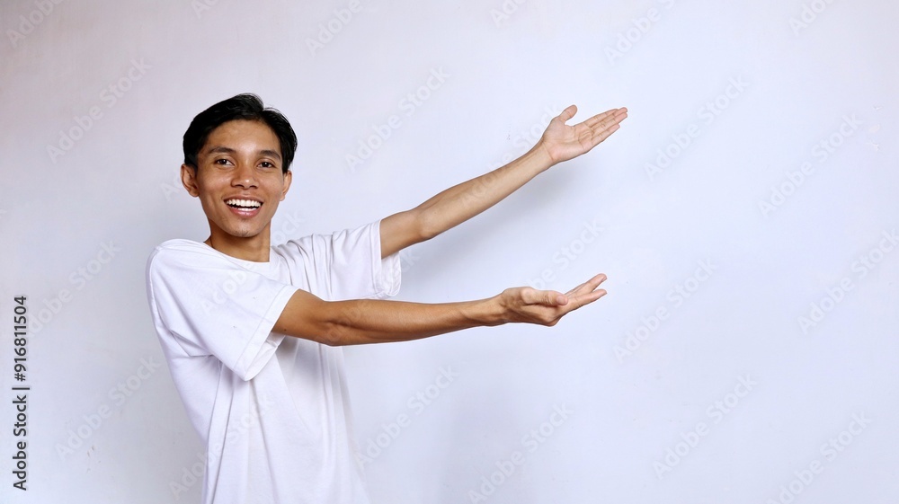 happy young asian man posing showing copy space on the side with both hands happy young asian man posing showing copy space on the side with both hands