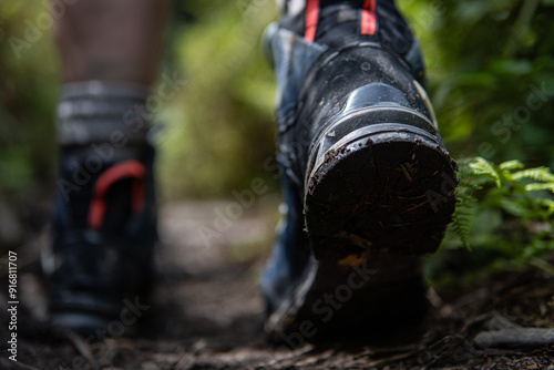 Close-up of hiking boots on a trail, symbolizing a mountain adventure and outdoor exploration. Perfect for concepts related to trekking, nature, and wilderness travel.