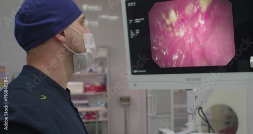 During a gastroscopy, the doctor carefully examines the gastric mucosa on the monitor. The doctor performs a gastroscopy and sees the digestive system on the monitor in front of him.