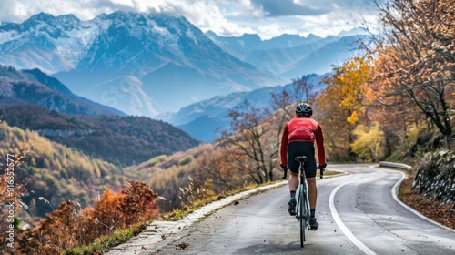 Cyclist Riding Down a Winding Road Through Autumnal Mountains