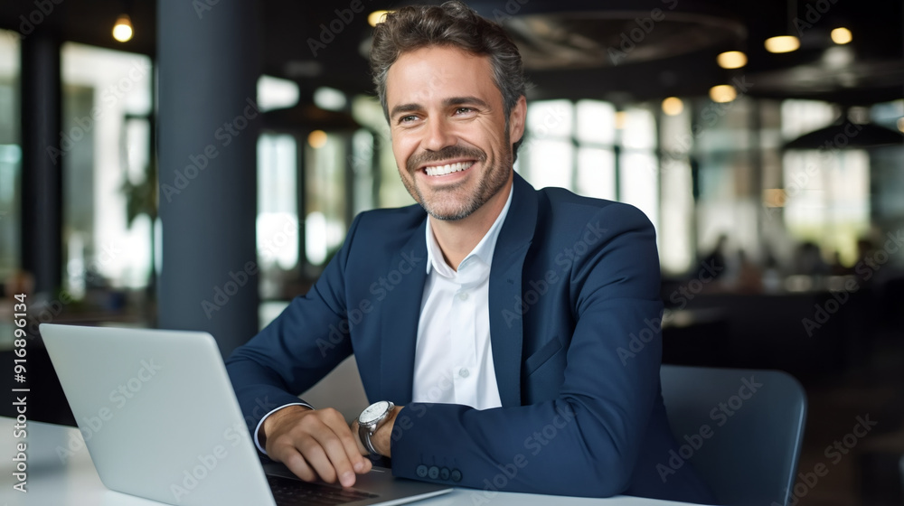 Portrait of a happy business man with a laptop smiling at the camera in an office. Portrait of a happy business man with a laptop smiling at the camera in an office.