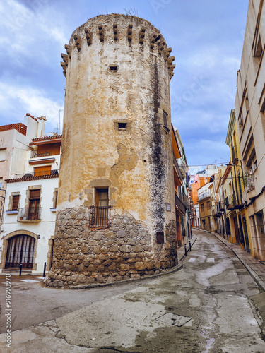 Narrow streets of the old town. Beautiful colorful facades with gates and balconies. Arenys de Mar. Catalonia. Spain. photo