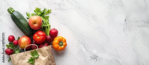 Fototapeta Naklejka Na Ścianę i Meble -  Various fresh vegetables and fruits in a paper bag arranged on a white marble surface for a vegan food delivery ideal for adding text alongside the copy space image