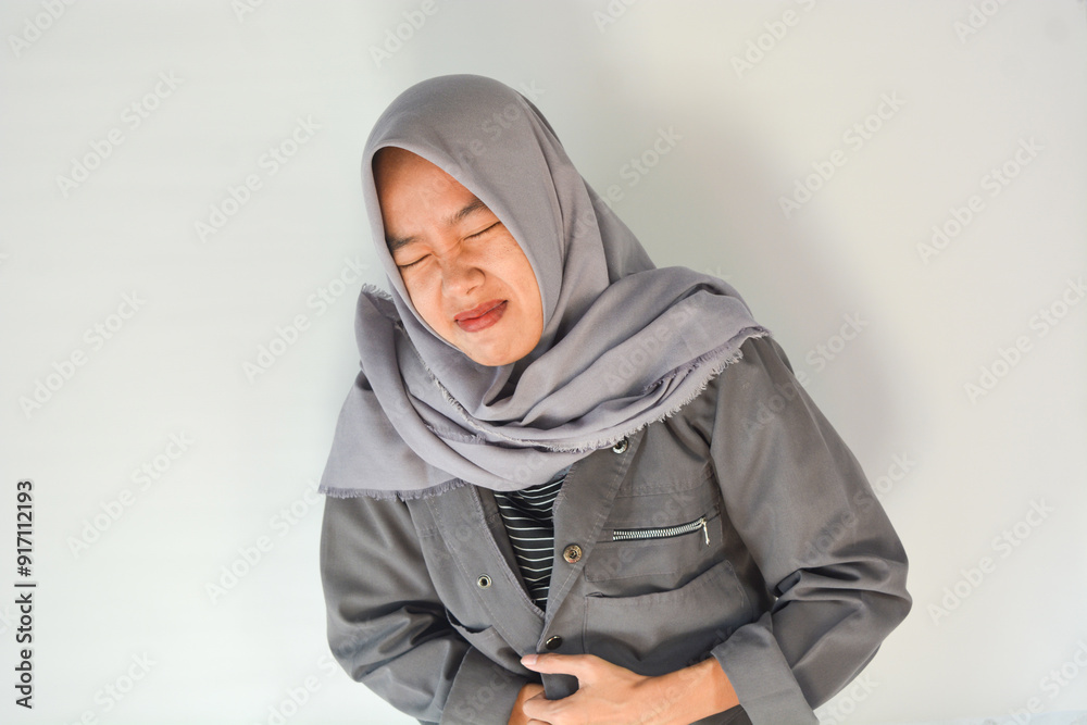 Young asian woman suffering from stomach ache in bed at home, space for text. Food poisoning Young asian woman suffering from stomach ache in bed at home, space for text. Food poisoning