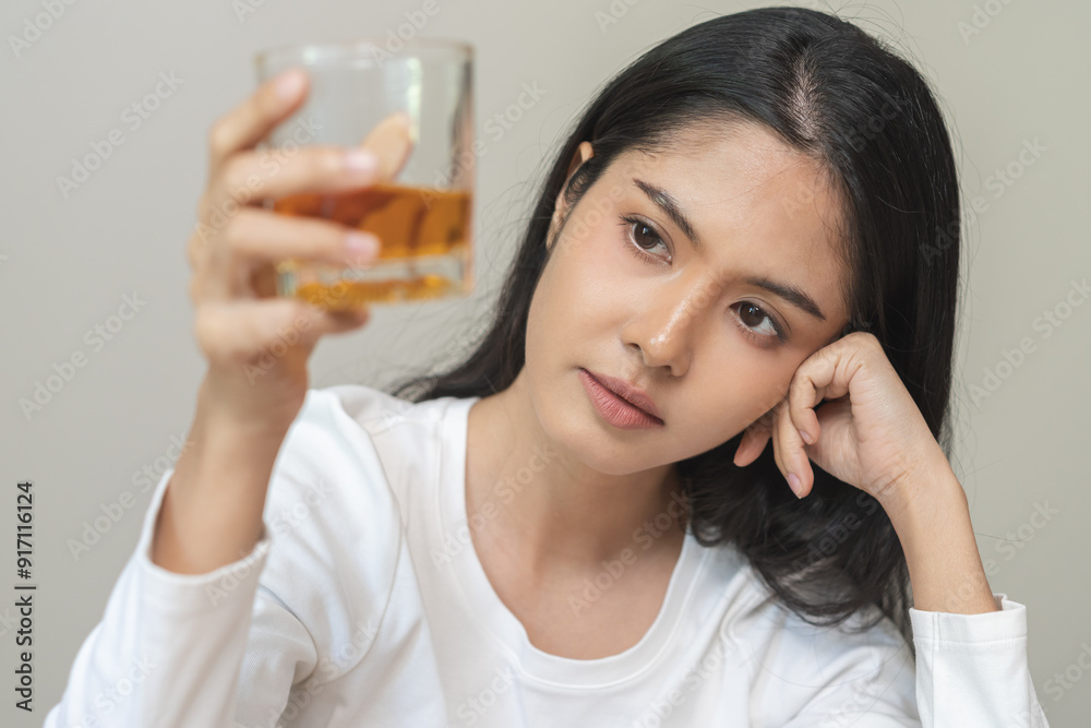 Alcoholism drunk, sad asian young woman hand holding glass of alcohol or whiskey, alone depressed female drink booze on background. Treatment of alcohol addiction, suffer abuse problem alcoholism. Alcoholism drunk, sad asian young woman hand holding glass of alcohol or whiskey, alone depressed female drink booze on background. Treatment of alcohol addiction, suffer abuse problem alcoholism.