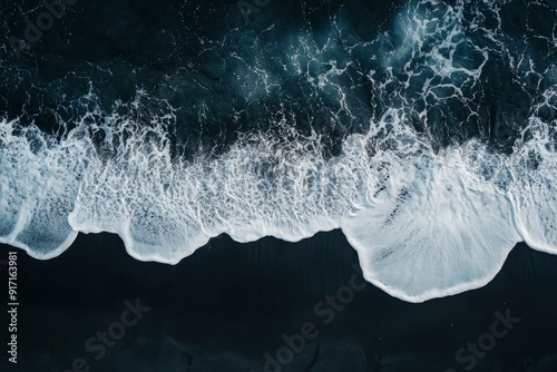aerial top down view of beautiful white blue water waves splashing over dark beach , ai