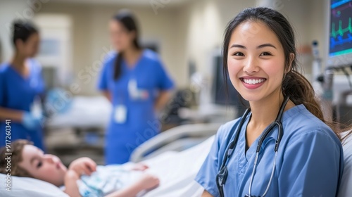 Souriant child on the floor of a hospital bed befriended by a nurse photo