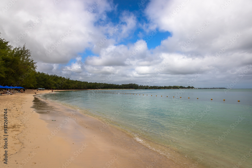Exposure of the beautiful Mon Choisy Beach, located ion the northwest of the Mauritius Island, a long stretch of soft white sand curves around a turquoise bay fringed by casuarina trees Exposure of the beautiful Mon Choisy Beach, located ion the northwest of the Mauritius Island, a long stretch of soft white sand curves around a turquoise bay fringed by casuarina trees