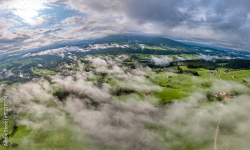 Aerial view landscape with low level clouds and overcast sky in the Bregenz Forest Mountains, Vorarlberg, Austria 