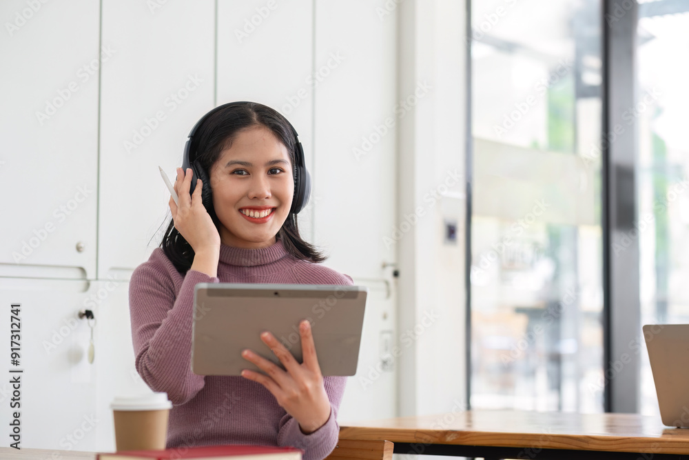 Young Woman Studying Online with Tablet and Headphones in Modern Home Environment Young Woman Studying Online with Tablet and Headphones in Modern Home Environment