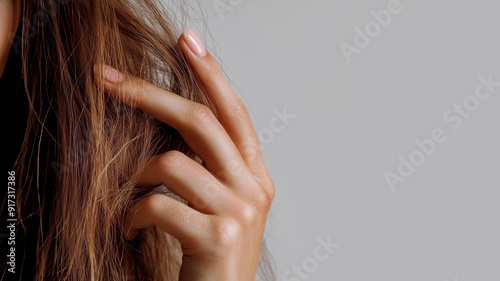 Brittle, dry hair. Disappointed woman holds her hair in her hand.  photo