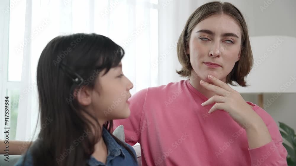 Caucasian mother telling her story to cute daughter while girl listening the fairytail. Happy mom tell and exchange experience to young student while happy attractive child sitting at sofa. Pedagogy. Caucasian mother telling her story to cute daughter while girl listening the fairytail. Happy mom tell and exchange experience to young student while happy attractive child sitting at sofa. Pedagogy.