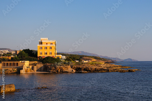 Yellow Villa Overlooking Rocky Coastline photo