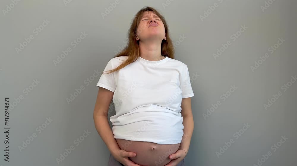 Sad angry exhausted pregnant woman is suffering because of pregnancy and big belly