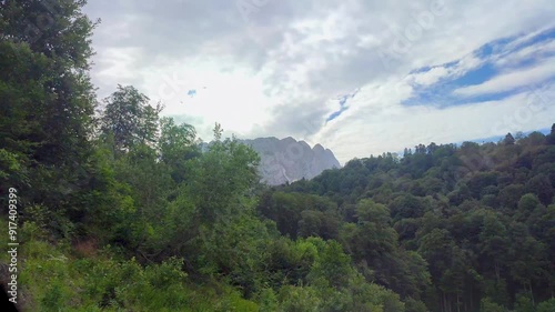 Summer road in the green mountains. View from the car on a winding mountain road.