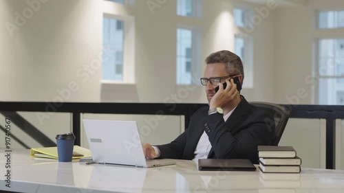 Wallpaper Mural Business worker talking on phone working with laptop at office. Employee working in office. Businessman have phone meeting. Business man chatting on phone. Business man using phone at workplace. Torontodigital.ca