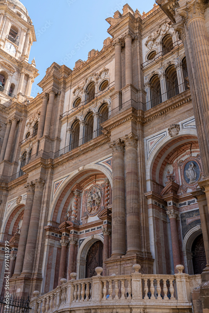 A striking view of the intricate facade of Málaga Cathedral, showcasing its grand architecture against a clear blue sky. Ideal for themes of historic landmarks, architecture, and Spanish heritage. A striking view of the intricate facade of Málaga Cathedral, showcasing its grand architecture against a clear blue sky. Ideal for themes of historic landmarks, architecture, and Spanish heritage.