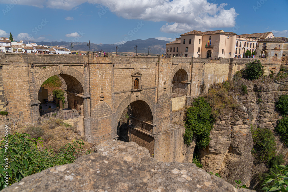 The iconic Puente Nuevo Bridge in Ronda, Spain, gracefully arches over the deep Tajo Gorge, with historic buildings perched on the cliffs. Perfect for themes of architecture, history, and travel. The iconic Puente Nuevo Bridge in Ronda, Spain, gracefully arches over the deep Tajo Gorge, with historic buildings perched on the cliffs. Perfect for themes of architecture, history, and travel.