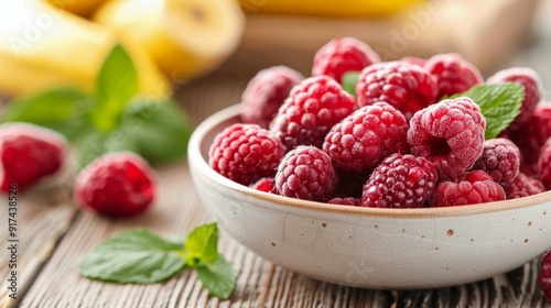 Fresh Raspberries and Bananas in a Bowl on a Wooden Table